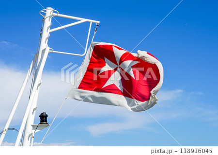 Maltese flag on the stern of a cruise ship against a blue sky background 118916045