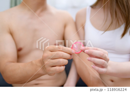 避妊具着用を勧める女性 コンドームを持つ若い女性の手 避妊具を持つ男女カップル 夫婦 妊活 性的同意 避妊具着用を勧める女性 コンドームを持つ若い女性の手 避妊具を持つ男女カップル 夫婦 妊活 性的同意 118916224