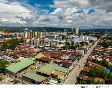 City landscape with modern building and small houses. Blue sky and clouds. Cagayan de Oro. Mindanao, Philippines. City landscape with modern building and small houses. Blue sky and clouds. Cagayan de Oro. Mindanao, Philippines. 118916272