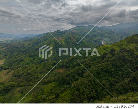 Tropical mountain slopes and hills with lush foliage in the Philippines. Blue sky and clouds. Mindanao. Tropical mountain slopes and hills with lush foliage in the Philippines. Blue sky and clouds. Mindanao. 118916274