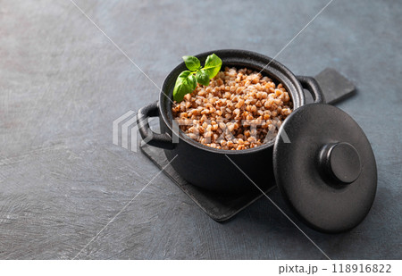 Buckwheat porridge in a black pan on a dark  background. 118916822