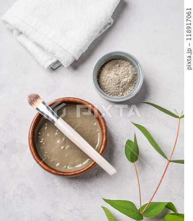Blue clay with brush on a light background with towel and branch. Blue clay with brush on a light background with towel and branch. 118917061