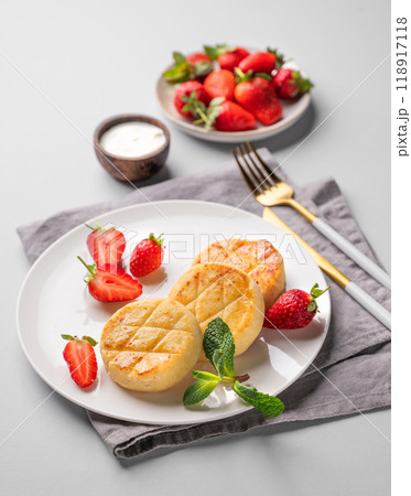 Cottage cheese, cheesecakes or syrniki with strawberries, sour cream and mint leaves  118917118