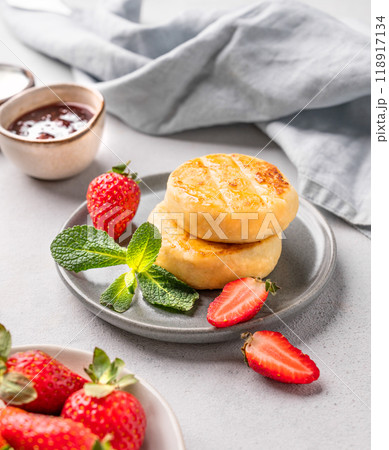 Cottage cheese, cheesecakes or syrniki with strawberries, berry jam and mint leaves  118917134