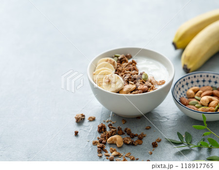 Baked granola with yogurt and banana on a white table. 118917765