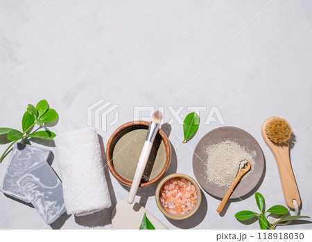 Organic blue clay, sea salt, soap, brush and towel on a light background with shadow. 118918030