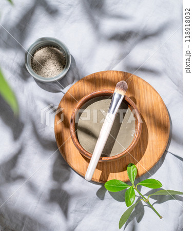 Organic cosmetic blue clay in a bowl with a brush on a wooden board on a linen background Organic cosmetic blue clay in a bowl with a brush on a wooden board on a linen background 118918032