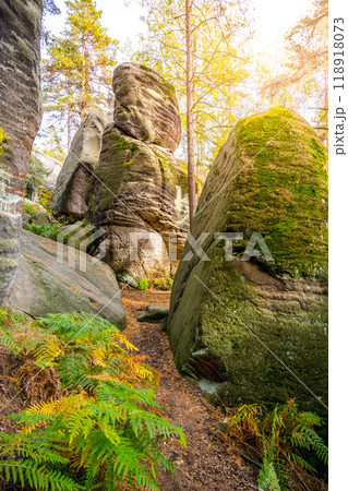 Wander through the stunning Besedice Rocks during autumn, where vibrant foliage contrasts with towering rock formations and serene paths, inviting adventure and tranquility in the Bohemian Paradise. 118918073