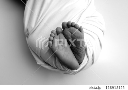 Foot of a newborn. Close up feet, toes, heels, feet of a newborn baby. Studio monochrome, vintage style, black and white macro photography. Foot of a newborn. Close up feet, toes, heels, feet of a newborn baby. Studio monochrome, vintage style, black and white macro photography. 118918123
