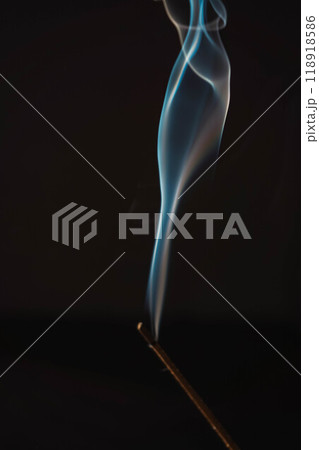 Incense burning smoke fumes and wisps. Aromatherapy smokes for yoga. Aroma sticks smoke on black background with white backlit. Burning aromatic incense smoky stick for meditation and relaxing. Incense burning smoke fumes and wisps. Aromatherapy smokes for yoga. Aroma sticks smoke on black background with white backlit. Burning aromatic incense smoky stick for meditation and relaxing. 118918586