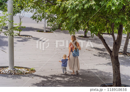 Mother with her toddler son walking in the park. Family bonding, outdoor exploration, and parenting concept 118918638