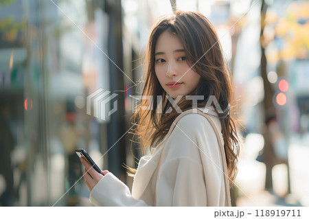 困惑の表情が印象的、スマホを見つめる女性 118919711