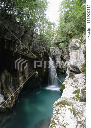 Beautiful waterfall in the big gorge rock cliffs of emerald soca river Beautiful waterfall in the big gorge rock cliffs of emerald soca river 118920512