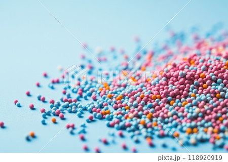 Colorful small candy sprinkles scattered on a light blue background creating a vibrant and playful atmosphere during a baking session 118920919
