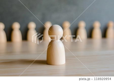 Wooden figures arranged in a creative lineup with one in focus highlighting teamwork and collaboration 118920954
