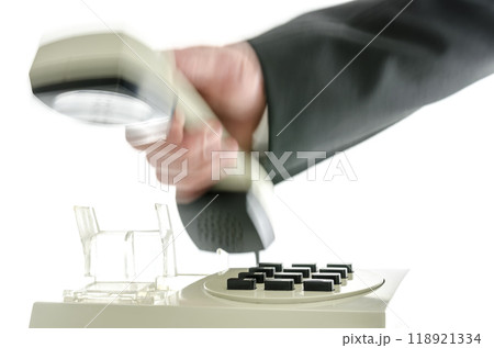 Blurred hand hanging up telephone receiver Blurred hand hanging up telephone receiver 118921334