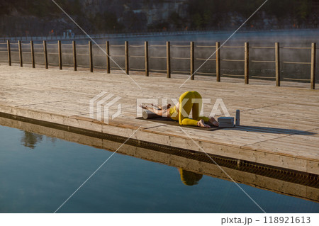 Engaging in Morning Yoga by the serene Water can truly rejuvenate your mind and body Engaging in Morning Yoga by the serene Water can truly rejuvenate your mind and body 118921613