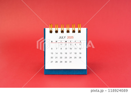 July 2025 white desk calendar on red background. July 2025 white desk calendar on red background. 118924089