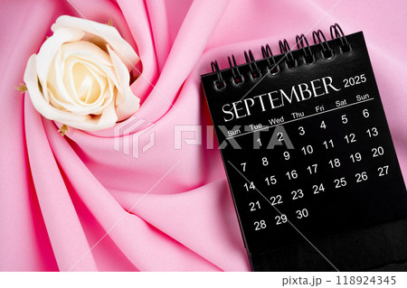 September 2025 desk calendar black color and rose on textile background. September 2025 desk calendar black color and rose on textile background. 118924345