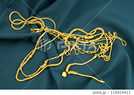 Many gold necklaces on green color velvet cloth 118924411