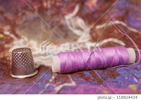 Thimble With Needle and Purple Thread on Vintage Lace Fabric Thimble With Needle and Purple Thread on Vintage Lace Fabric 118924434