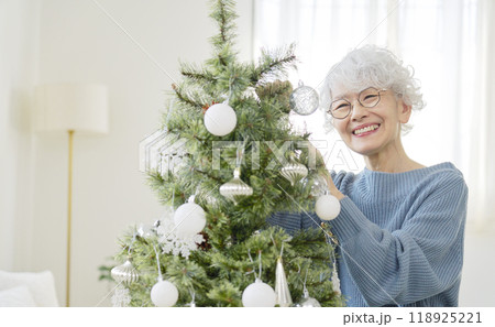 クリスマスツリーのオーナメントを飾るシニア女性 118925221