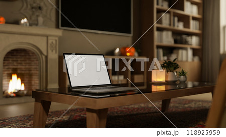 A close-up of a laptop mockup on a dark coffee table in a cozy contemporary living room at night. 118925959