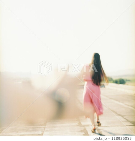 光に照らされている女性を追いかける人の手 118926055
