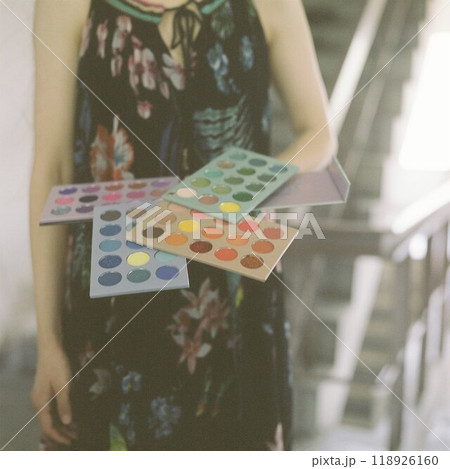 カラフルなアイカラーのパレットを持つ女性 118926160