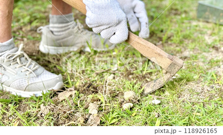 軍手をして片手鍬で地面を掘る高齢女性の手元 軍手をして片手鍬で地面を掘る高齢女性の手元 118926165