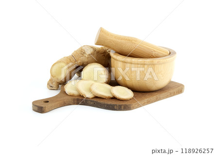 Sliced ginger root with mortar and pestle isolated on white background 118926257