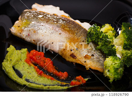 Grilled trout on black dish with broccoli and tartar sauce Grilled trout on black dish with broccoli and tartar sauce 118926790