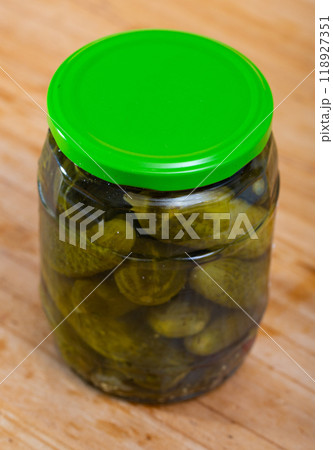 Glass jar with pickled cucumbers on wooden background 118927351