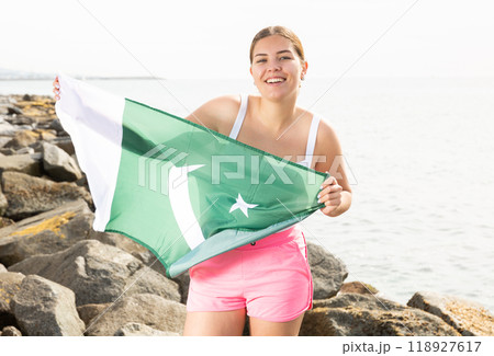 Young woman on coast posing with flag of Pakistan 118927617