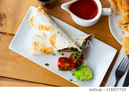 Delicious lula-kebab in lavash with vegetables and herbs 118927720