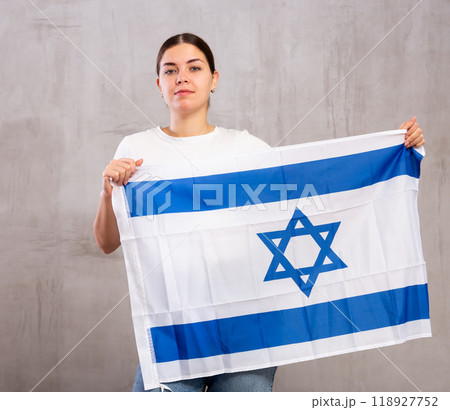 Focused woman holding Israel flag Focused woman holding Israel flag 118927752