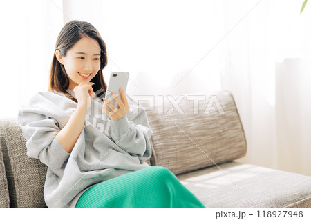 ソファに座ってスマホを見る女性 ソファに座ってスマホを見る女性 118927948