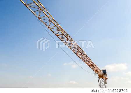 Industrial construction crane with blue sky background at building site 118928741