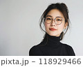 Beautiful studio portrait of young, stylish, beautiful asian woman, long hair, with modern design eye glasses looking at camera with confidence on white background 118929466