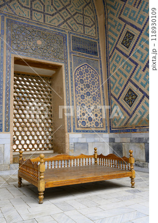 Traditional Asian carved wooden cot in Ulugbek Madrasah of the 14th century in Samarkand, Uzbekistan 118930109