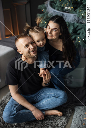 Happy family with young child near decorated Christmas tree Happy family with young child near decorated Christmas tree 118931264
