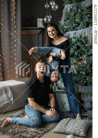 Happy family playing together by Christmas tree at home 118931279