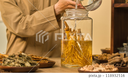 The image template depicts a scientist starting the ginseng soaking procedure by adding water to a large glass jar filled with the root vegetable. 118932516