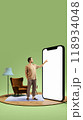 Man standing alone in simple room, pointing at giant 3D model of phone with blank screen. Use of mobile apps for efficiency and fast online services. 118934048