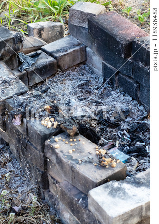 A fire pit that has been constructed using bricks set in the dirt 118936488