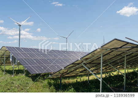 Solar panels and wind turbines on a field. Sustainable energy 118936599