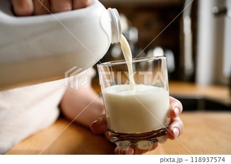 Girl with milk at kitchen at home 118937574