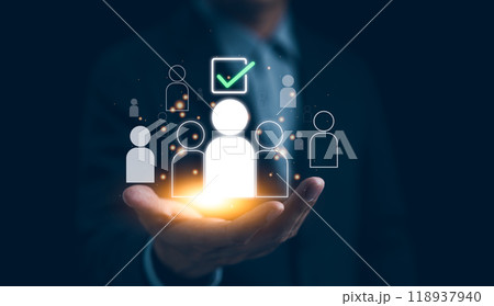 Human Resources Recruitment and Hiring Concept. Businessman holds virtual icons representing potential candidates, with one icon highlighted and a check mark, illustrating HR recruitment and hiring. Human Resources Recruitment and Hiring Concept. Businessman holds virtual icons representing potential candidates, with one icon highlighted and a check mark, illustrating HR recruitment and hiring. 118937940