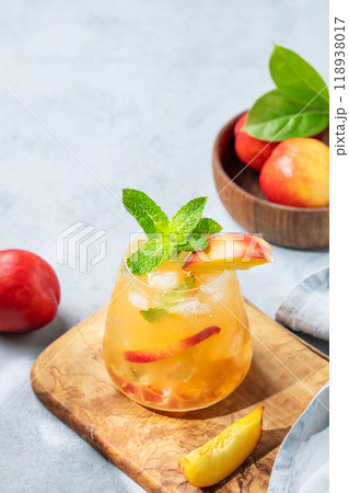 Refreshing peach cocktail, lemonade or iced tea on a wooden board on a blue background. Refreshing peach cocktail, lemonade or iced tea on a wooden board on a blue background. 118938017