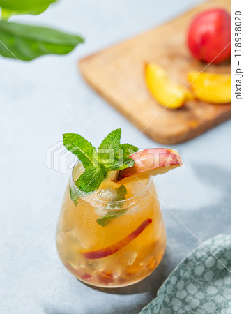 Refreshing peach cocktail, lemonade or iced tea on a light background with shadow. 118938020